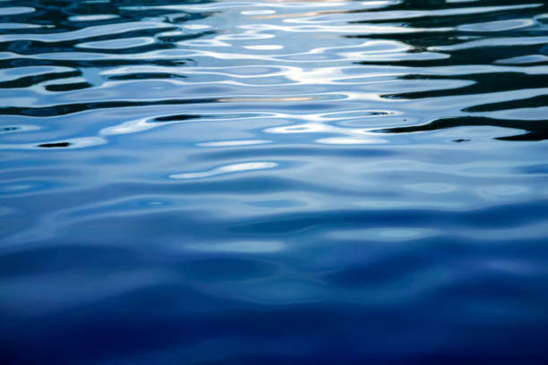 Clear water droplets creating gentle ripples on a calm surface